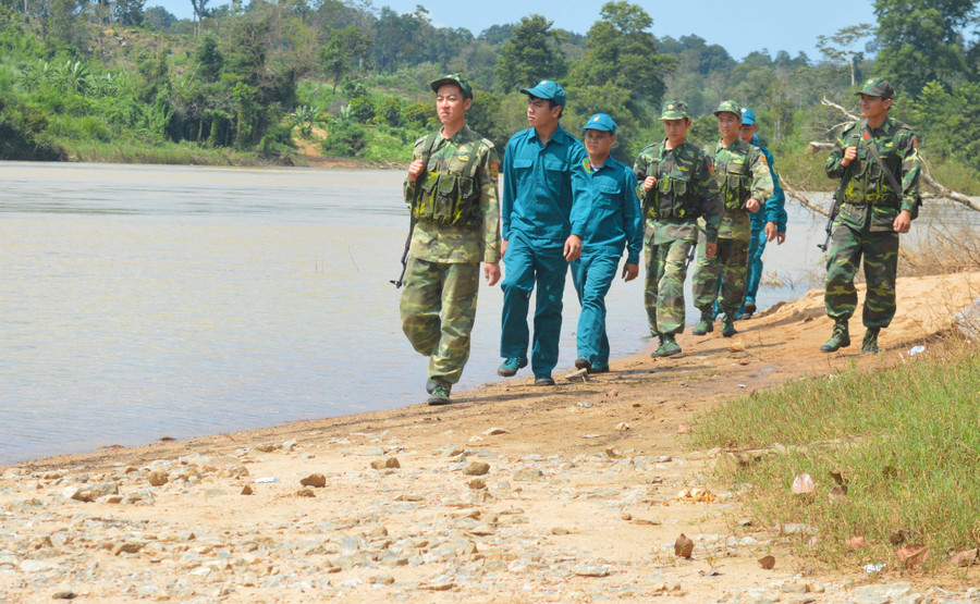 Thượng úy Trần Xuân Nam (bìa phải) cùng cán bộ, chiến sĩ trong Đội Vũ trang và lực lượng dân quân tuần tra bảo vệ biên giới. Ảnh: Anh Huy 