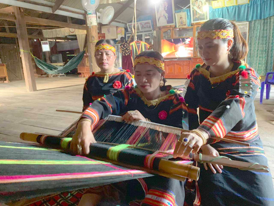 Chị R’Ô H’Luy (giữa) chia sẻ kinh nghiệm dệt thổ cẩm cho chị em trong chi hội. Ảnh: Vũ Chi 