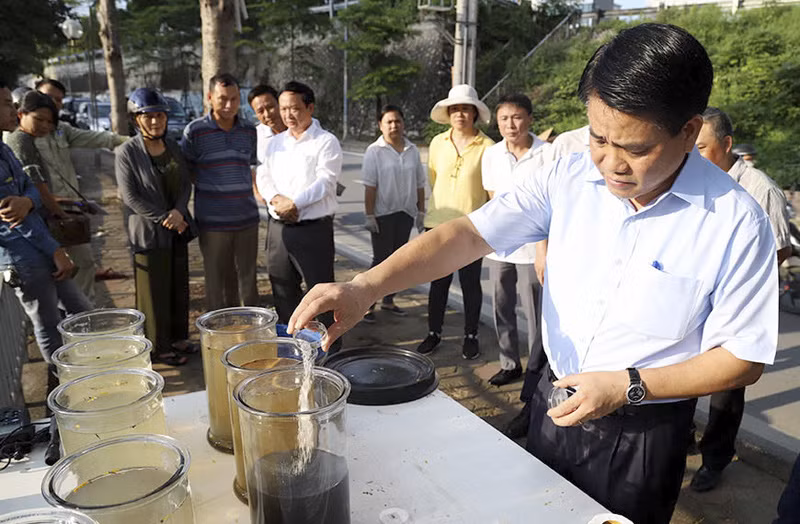 Chủ tịch UBND TP.Hà Nội Nguyễn Đức Chung kiểm tra việc thử nghiệm làm sạch sông Tô Lịch bằng chế phẩm Redoxy-3C. (Ảnh: Thành Nam)