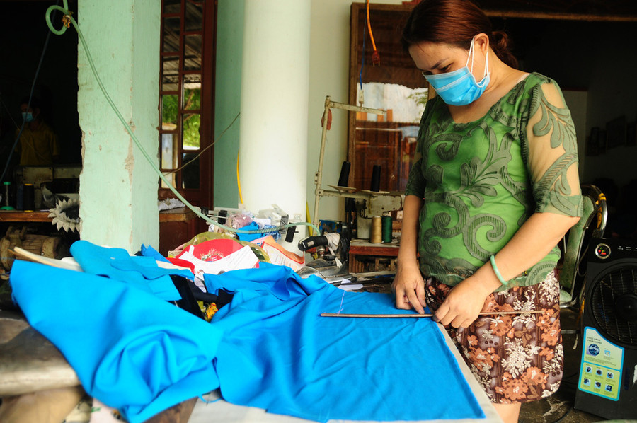 Chị Nguyễn Thị Minh Hương, thợ may ở khu dân cư Lưu Minh, mấy hôm nay vẫn cặm cụi làm việc trong khuôn viên nhà. Công việc sẽ giúp chị cùng gia đình bớt nặng nề trong những ngày có dịch - Ảnh: B.D