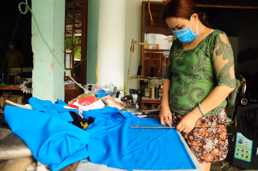 Chị Nguyễn Thị Minh Hương, thợ may ở khu dân cư Lưu Minh, mấy hôm nay vẫn cặm cụi làm việc trong khuôn viên nhà. Công việc sẽ giúp chị cùng gia đình bớt nặng nề trong những ngày có dịch - Ảnh: B.D