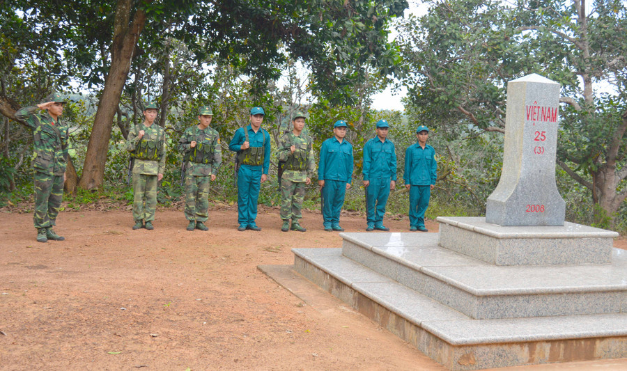 Thượng úy Nam (bên trái) cùng đội vũ trang và lực lượng dân quan đang tuần tra cột mốc. Ảnh: Phương Dung 