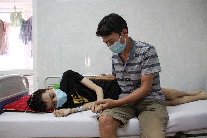 Ông Quân chăm sóc con trai tại bệnh viện ẢNH; HOÀNG BÌNH