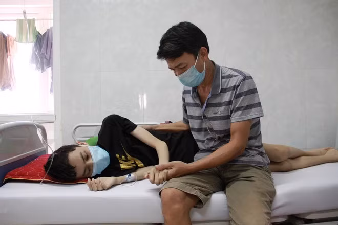 Ông Quân chăm sóc con trai tại bệnh viện ẢNH; HOÀNG BÌNH