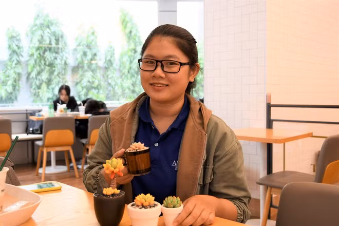 Dung và các sản phẩm sen đá từ đất sét của mình. Ảnh: HOA NỮ