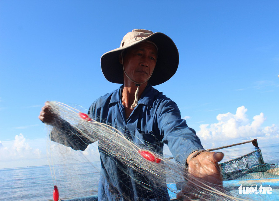 Ngư dân gỡ lưới chuẩn bị cho chuyến ra khơi thứ hai trong ngày - Ảnh: THANH NGÂN