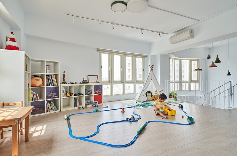 Một phòng chơi đặt cạnh cầu thang, với lan can sắt dày đảm bảo an toàn cho bé.