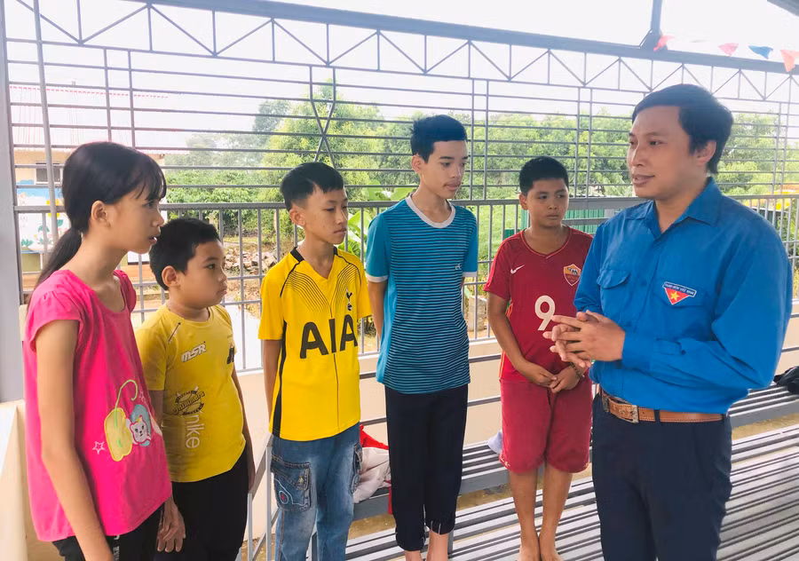 Anh Lều Vũ Thanh (bìa phải) vận động các em thiếu nhi tham gia lớp dạy bơi miễn phí. Ảnh: Thủy Bình 