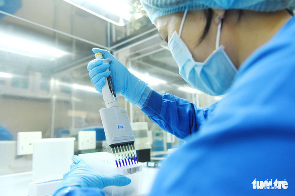 Kỹ thuật viên Bệnh viện Bệnh nhiệt đới TP.HCM bơm dung dịch Lysis trước khi tiến hành tách chiết mẫu bệnh phẩm để xét nghiệm COVID-19 - Ảnh: DUYÊN PHAN