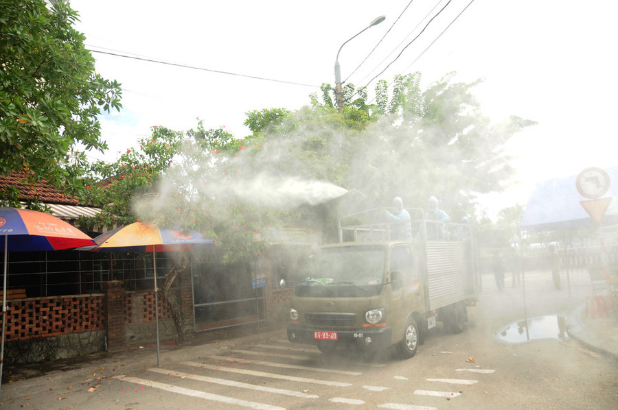 Khu vực quán cà phê, nơi sinh sống của gia đình có 7 người dương tính với COVID-19 tại Lưu Minh, được phun hóa chất kỹ lưỡng - Ảnh: B.D