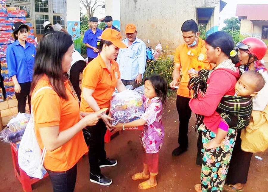  Các thành viên Đoàn từ thiện Hạnh Ngộ yêu thương tặng quà cho các hộ gia đình có hoàn cảnh khó khăn. Ảnh: Anh Quân