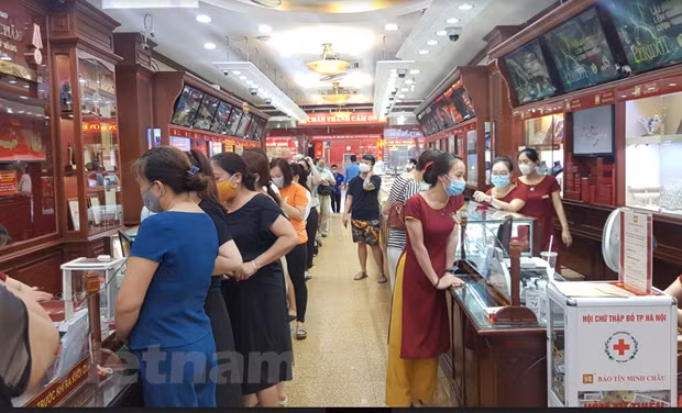 Nhiều người dân xếp hàng mua bán vàng tại Bảo Tín Minh Châu trên phố Trần Nhân Tông, Hà Nội chiều ngày 6/8. (Ảnh: PV/Vietnam+)