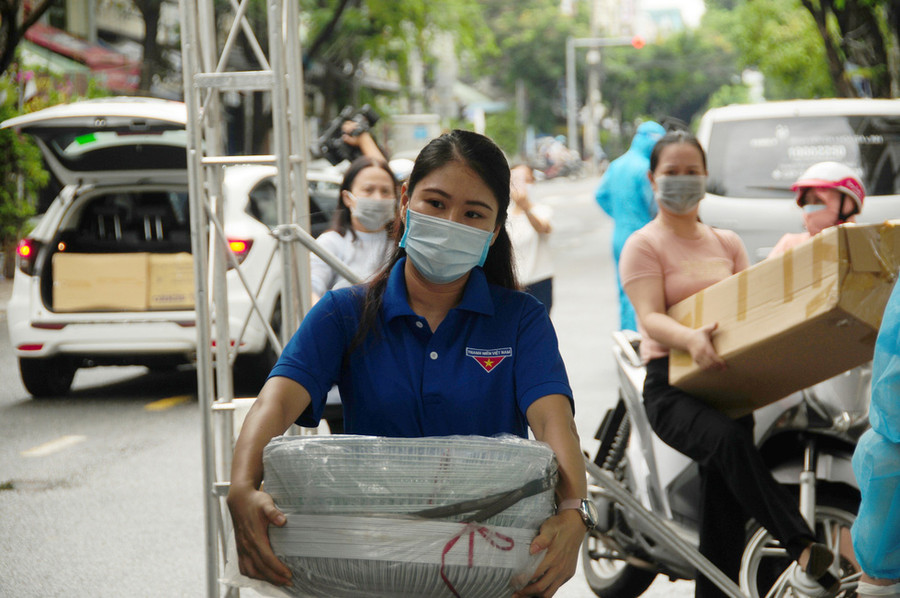Các tình nguyện viên phụ tiếp tế hàng hóa, vật tư y tế, nhu yếu phẩm - Ảnh: T.B.D