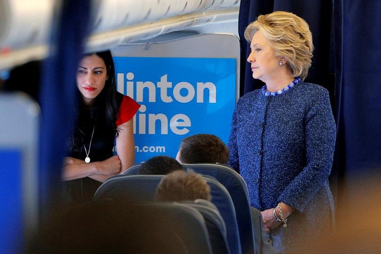 Bà Clinton nói chuyện với các phụ tá, trong đó có trợ lý Huma Abedin trên máy bay ở White Plains, New York hôm 28-10.