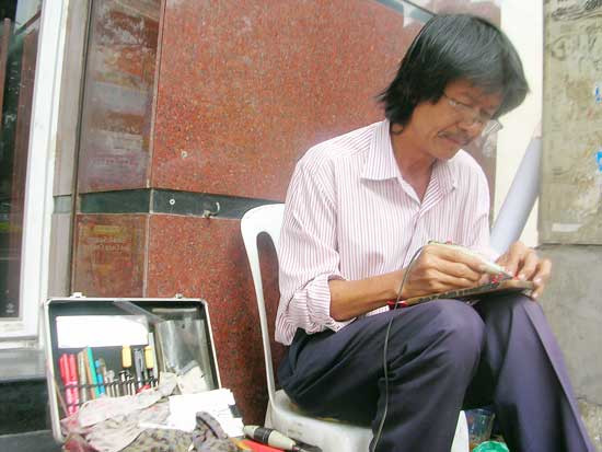 Ông Nguyễn Thắng đang tỉ mẩn khắc chữ lên cây bút. Ông Nguyễn Thắng đang tỉ mẩn khắc chữ lên cây bút.