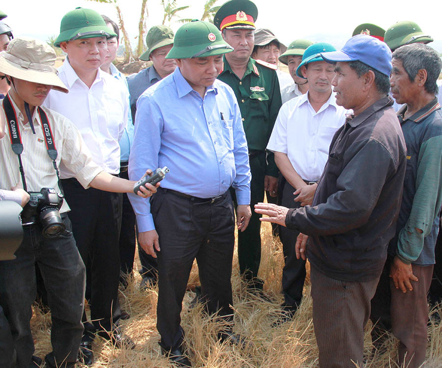Thủ tướng Nguyễn Xuân Phúc (đứng giữa) hỏi thăm bà con xã Chư Don (huyện Chư Pưh) về tình hình hạn hán. Ảnh: M.T