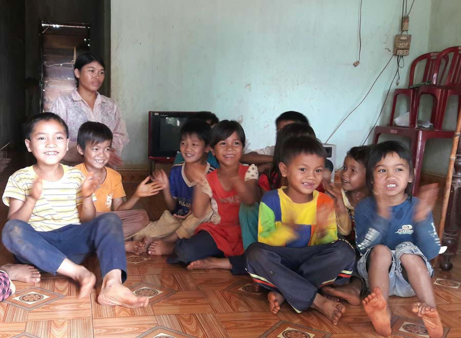 Vợ anh Rơ Chăm Hiếu cùng lũ trẻ con vui đùa trong ngôi nhà mình. Ảnh: Đỗ Hằng