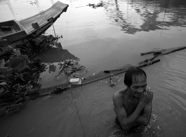 Ông Ba Chúc là ngư dân lâu năm và có tiếng ở khu vực này vì ngoài đánh cá ông còn kiêm thêm công việc vớt xác, cứu người. Gần 40 năm qua, hai vợ chồng ông đã cứu, vớt gần 300 người bị tai nạn và tự tử trên sông. Chiều lại, ông Chúc cũng như cánh đàn ông ở xóm chài đều tắm mình dưới sông. Phụ nữ thì múc nước sông lên, che chắn một góc trên ghe để tắm.