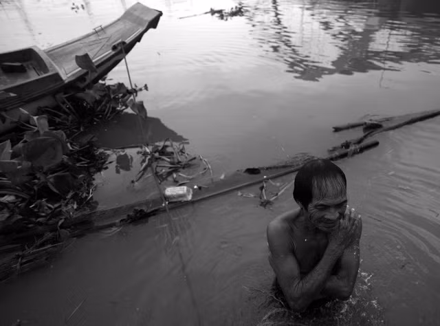 Ông Ba Chúc là ngư dân lâu năm và có tiếng ở khu vực này vì ngoài đánh cá ông còn kiêm thêm công việc vớt xác, cứu người. Gần 40 năm qua, hai vợ chồng ông đã cứu, vớt gần 300 người bị tai nạn và tự tử trên sông. Chiều lại, ông Chúc cũng như cánh đàn ông ở xóm chài đều tắm mình dưới sông. Phụ nữ thì múc nước sông lên, che chắn một góc trên ghe để tắm.