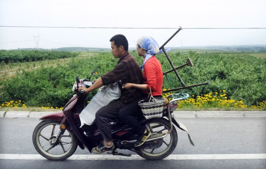 Một cặp vợ chồng nông dân Yên Đài mang theo cả bao tải lớn túi thuốc sâu ra ruộng táo.