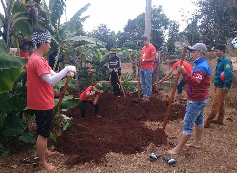  Các sinh viên tình nguyện đào hố rác cho bà con. Ảnh: P.L