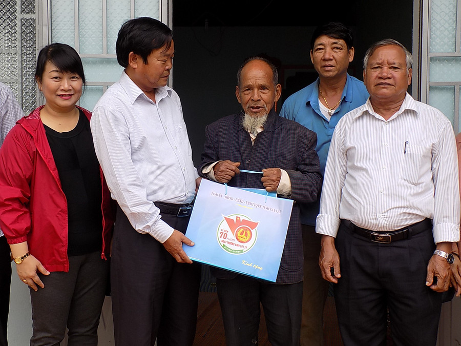  Tặng quà ông Siu Plim là thương binh, người có công cách mạng tại xã Ia Tô. Ảnh: T.N
