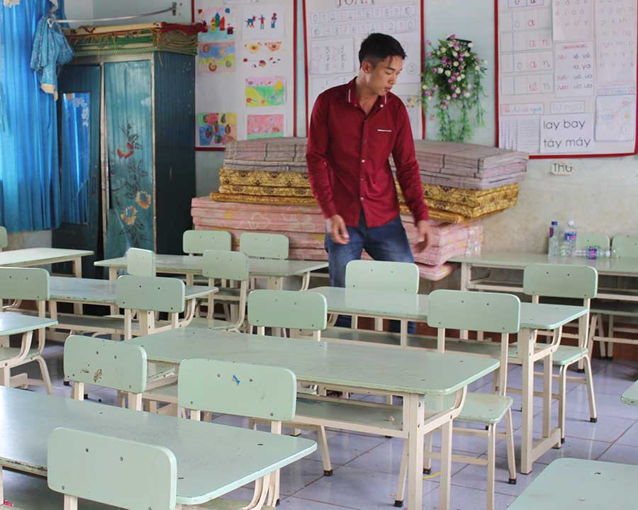  Nhân viên bảo vệ Trường Tiểu học Đak Djrăng sắp xếp bàn ghế trong dịp hè. Ảnh: N.G