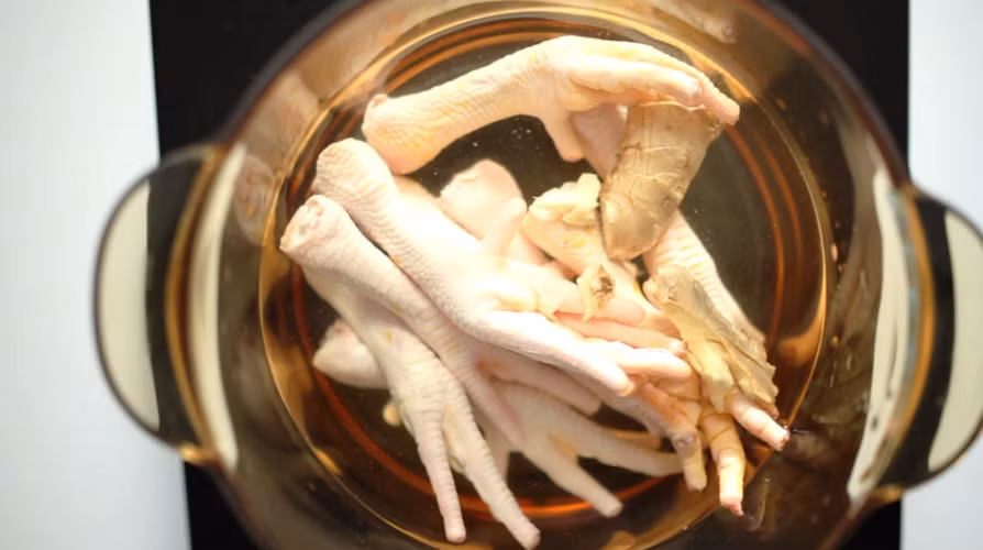 Cách làm: bài thuốc này được chế biến như những món ăn bình thường nên ai cũng có thể làm được. Sau khi làm sạch chân gà, bỏ chân gà và lạc vào nồi, cho thêm 1 lít nước + gia vị vừa miệng hầm trong khoảng 1 đến 1 tiếng rưỡi là được. Ảnh: Báo thanh niên.