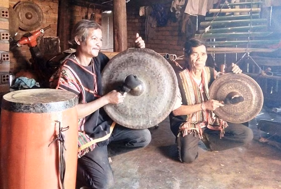 Nghệ nhân A Nol (phải) và ông A Thia đang thử chiêng. Ảnh: Dạ Yến Thảo