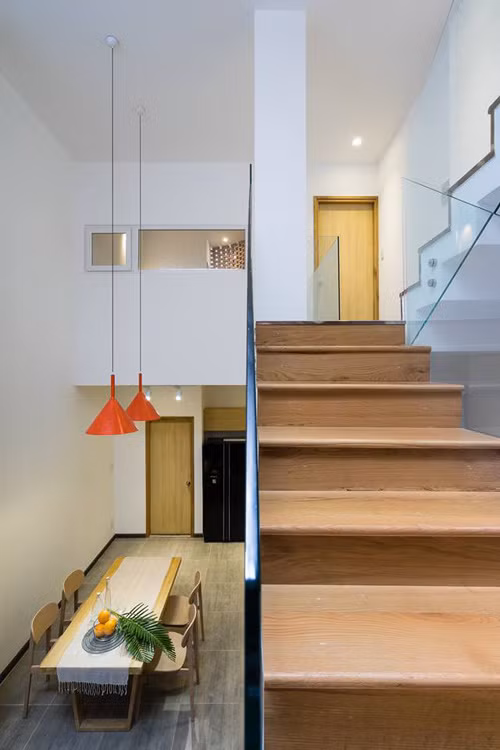 Phần thông tầng giúp phòng ăn trở nên cao, thoáng hơn. Kiến trúc sư cũng tối giản mọi yếu tố trang trí, để nhà đẹp nhờ chính các chi tiết vật liệu.