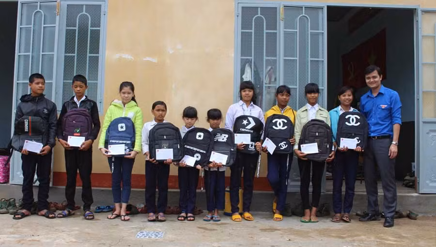 Đồng chí Bùi Quang Huy-Bí thư Trung Đoàn tặng học bổng cho các em học sinh nghèo tại xã Chư Jôr. Ảnh: Phan Lài