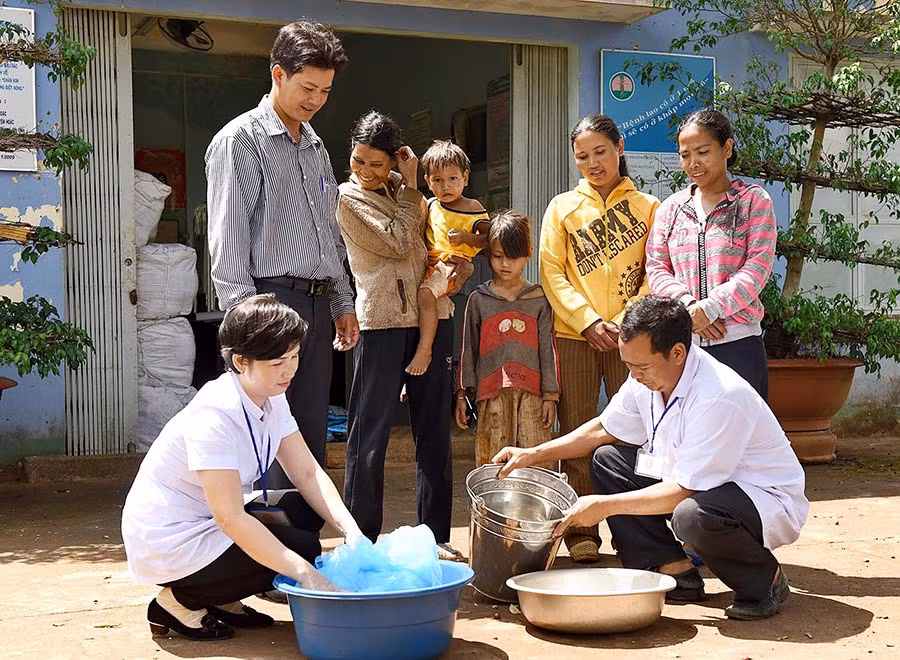  Cán bộ y tế hướng dẫn người dân tẩm màn phòng bệnh sốt rét. Ảnh: Đ.T