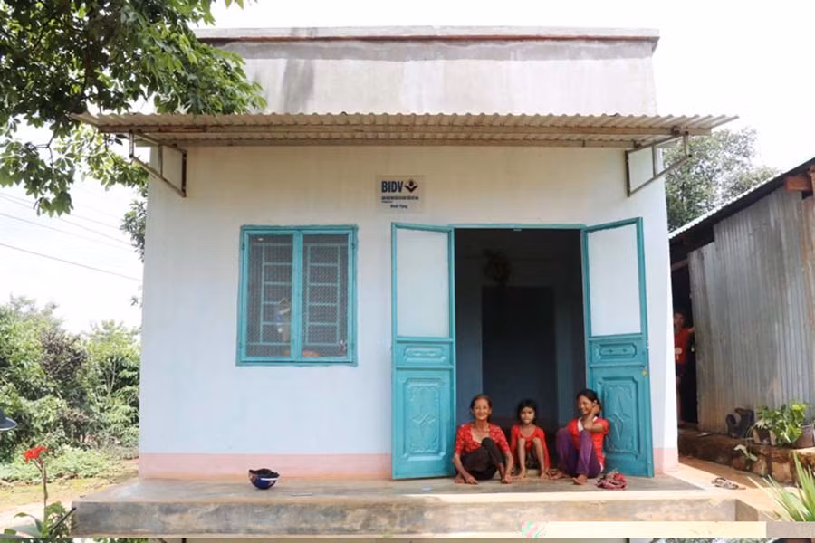  Bà Kpăh Panh cùng con gái và cháu ngoại trò chuyện trước căn nhà mới. Ảnh: N.H