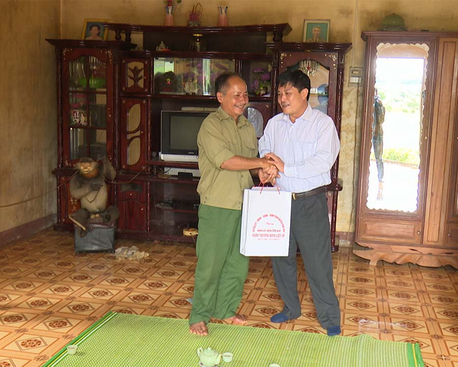 Đồng chí Bí thư Huyện ủy tặng quà cho các gia đình chính sách. Ảnh: Thu Hoài