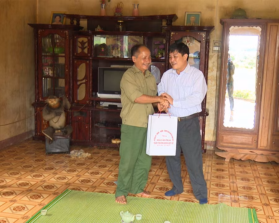 Đồng chí Bí thư Huyện ủy tặng quà cho các gia đình chính sách. Ảnh: Thu Hoài