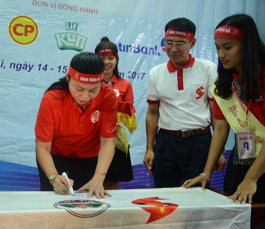 Phó Chủ tịch UBND tỉnh Huỳnh Nữ Thu Hà (bên trái) bút ký lên Lá cờ lưu niệm của Hành trình Đỏ 2017. Ảnh: P.L Phó Chủ tịch UBND tỉnh Huỳnh Nữ Thu Hà (bên trái) bút ký lên Lá cờ lưu niệm của Hành trình Đỏ 2017. Ảnh: P.L