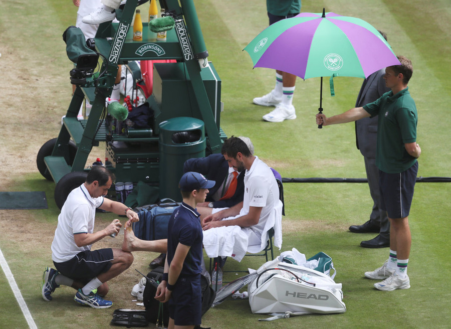 Cilic được các bác sỹ chăm sóc sau khi gặp vấn đề ở bàn chân trái. Ảnh: REUTERS Cilic được các bác sỹ chăm sóc sau khi gặp vấn đề ở bàn chân trái. Ảnh: REUTERS