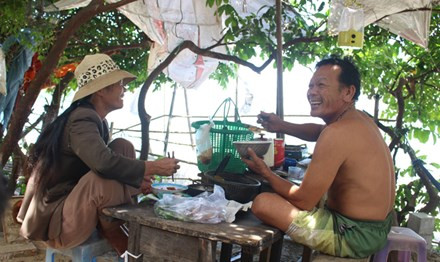 Bữa cơm ngập tiếng cười của vợ chồng ông Em - bà Liễu trước căn chòi nhỏ.