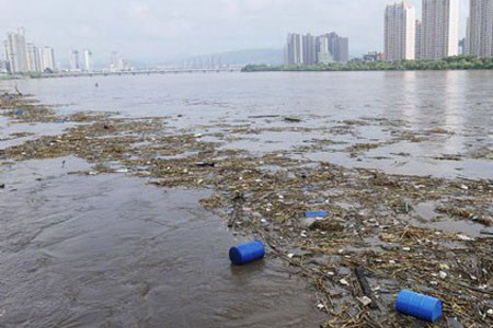 Các thùng hoá chất bị nước lũ cuốn trôi