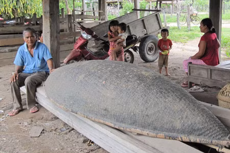 Ông Nay Nhoay cùng chiếc sõng- phương tiện phòng lũ của gia đình. Ảnh: Hồng Sơn