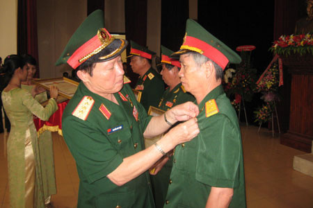 Thượng tướng Nguyễn Huy Hiệu- Thứ trưởng Bộ Quốc phòng đang trao danh hiệu AHLLVTND cho ông Nguyễn Văn Nhương. Ảnh: P.D