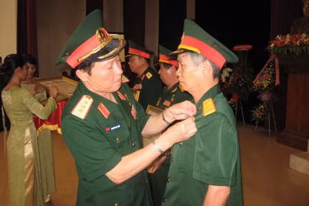 Thượng tướng Nguyễn Huy Hiệu- Thứ trưởng Bộ Quốc phòng đang trao danh hiệu AHLLVTND cho ông Nguyễn Văn Nhương. Ảnh: P.D