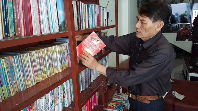Ông Lê Xuân Tình bên tủ sách miễn phí.