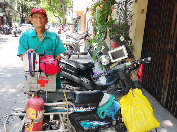 Ông Tống Văn Thơm bên chiếc xe chở dụng cụ cứu hộ, cứu nạn.
