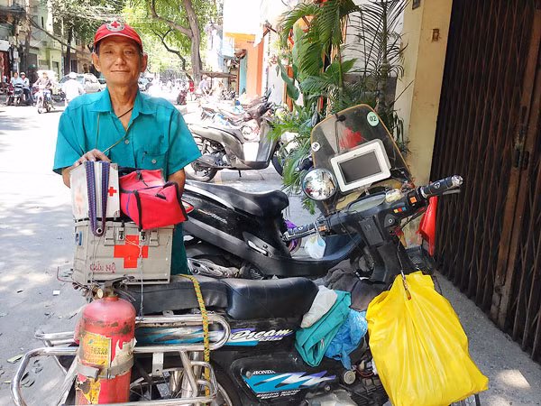 Ông Tống Văn Thơm bên chiếc xe chở dụng cụ cứu hộ, cứu nạn.