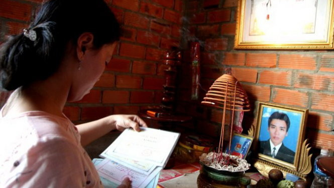 Chị Nguyễn Thị Ngọc Bảo trước di ảnh chồng mình - liệt sĩ Võ Văn Đấu