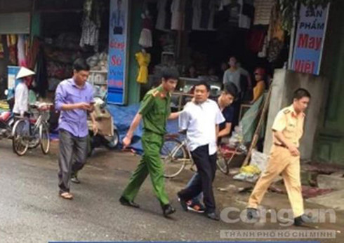 Đối tượng Thu (áo trắng) bị công an áp giải. (Ảnh: Công an TPHCM)