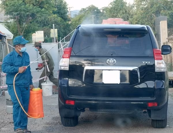 Lực lượng làm nhiệm vụ tại chốt kiểm tra y tế tại xã Cát Tường phun khử khuẩn phương tiện ra, vào địa phương