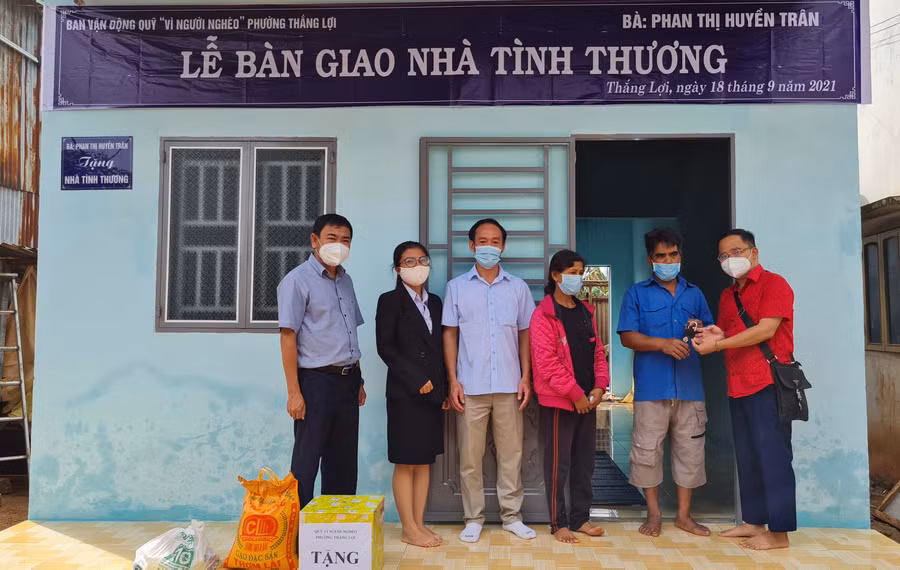 Ảnh 1: Đại diện mạnh thường quân trao chìa khóa nhà cho hộ nghèo.