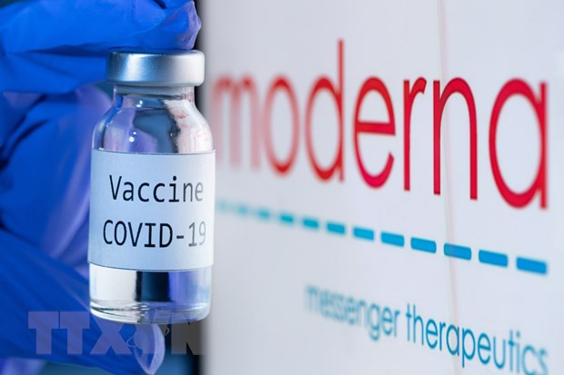 Vaccine ngừa COVID-19 bên cạnh biểu tượng của Công ty dược Moderna. Ảnh: AFP/TTXVN
